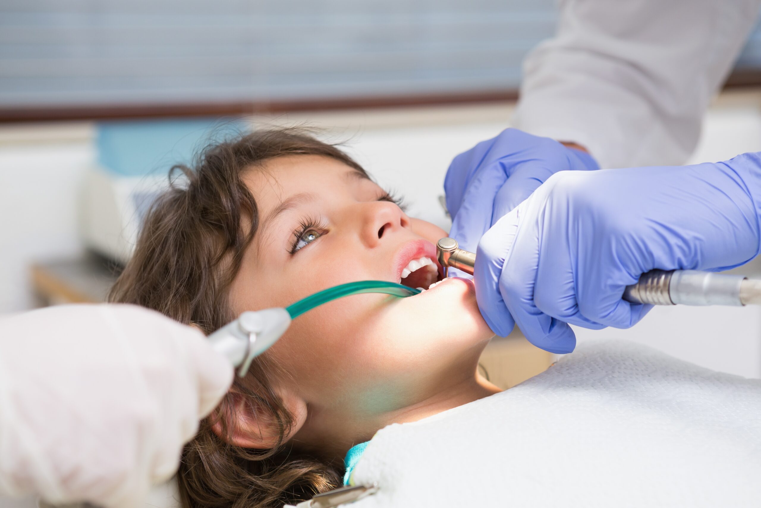 Pediatric dentist examining a boys teeth