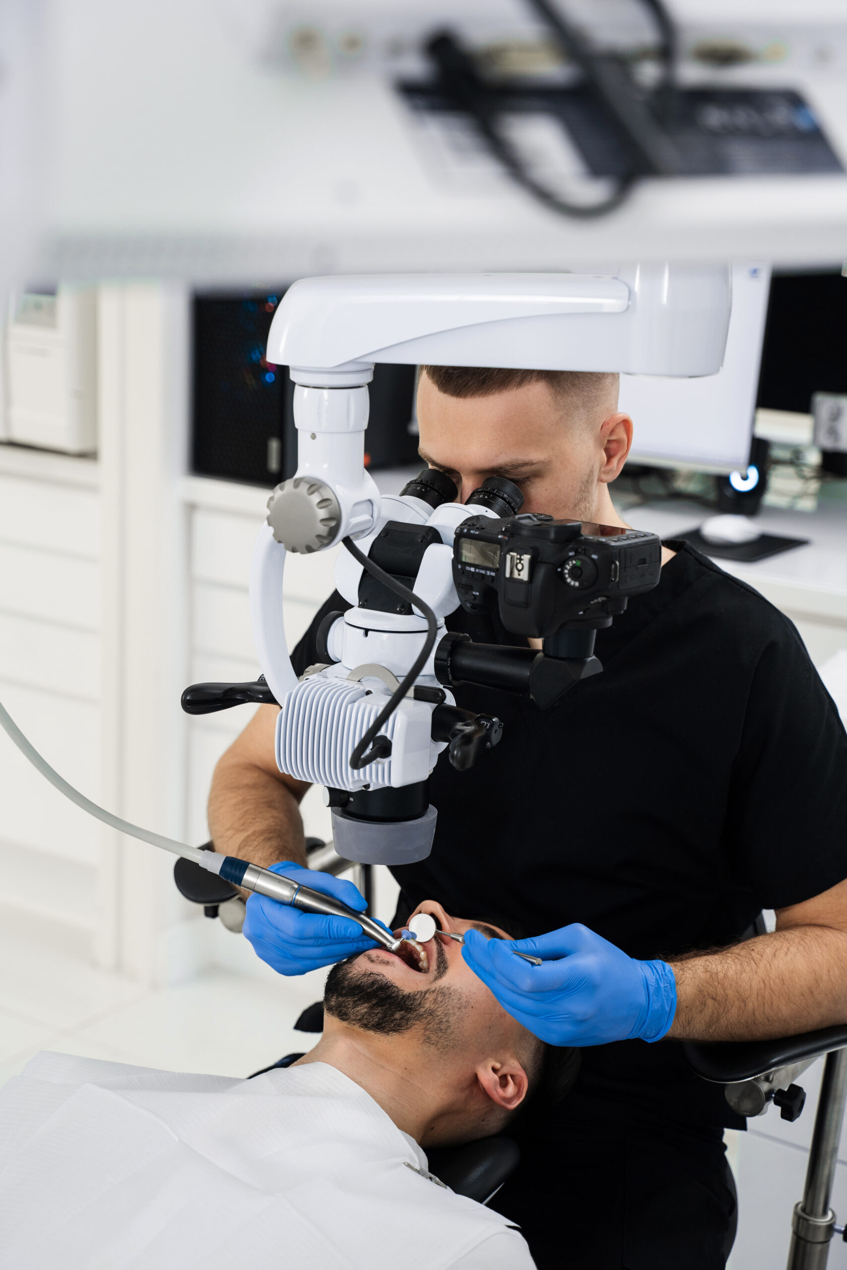 Dentist uses operating microscope to polish teeth of the patient. Operating dental digital microscope working process
