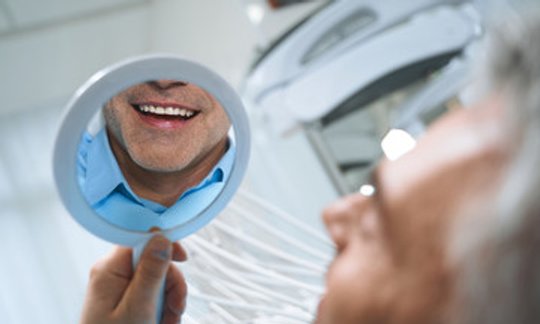 Smiling patient with bright white teeth after professional teeth whitening at Northside Family Dentistry