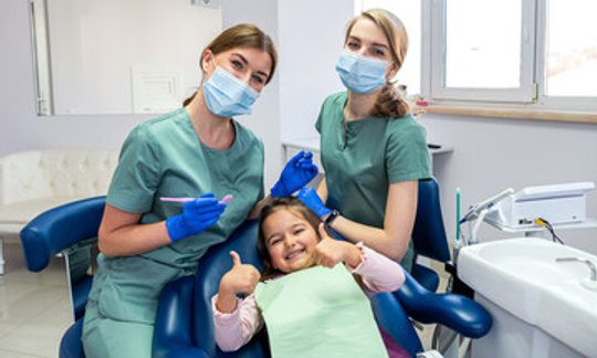Child smiling comfortably at the dentist office